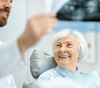 Woman smiling as dentist is explaning procedure