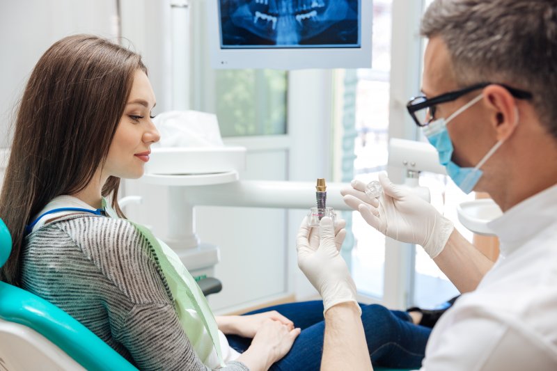 woman listening to dentist explain dental implants