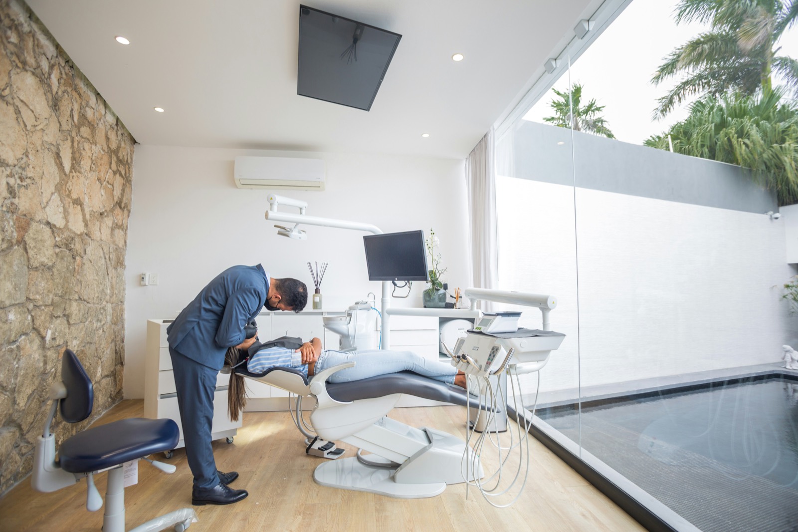 Dentist treating a patient in a bright, modern dental operatory
